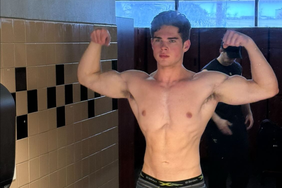 Influencer Clavicular showing his biceps in a gym photo