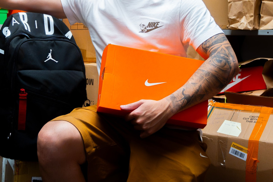Model holding Nike shoes in box