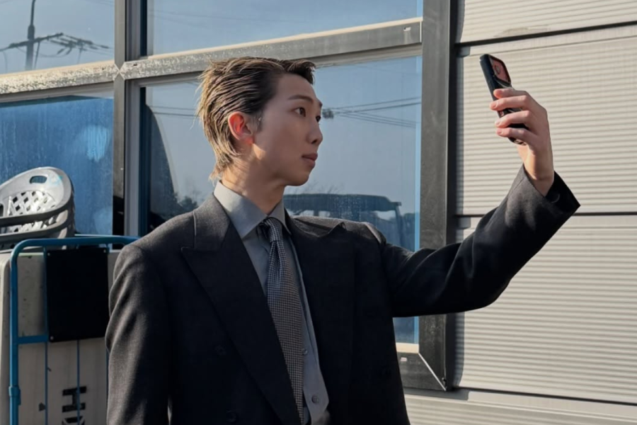 BTS RM holding a phone taking a selfie