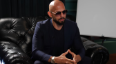 Andrew Tate in a formal attire wearing sunglasses
