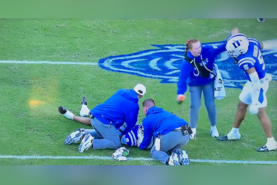 Duke cornerback Kimari Robinson swats a female trainer's arm.